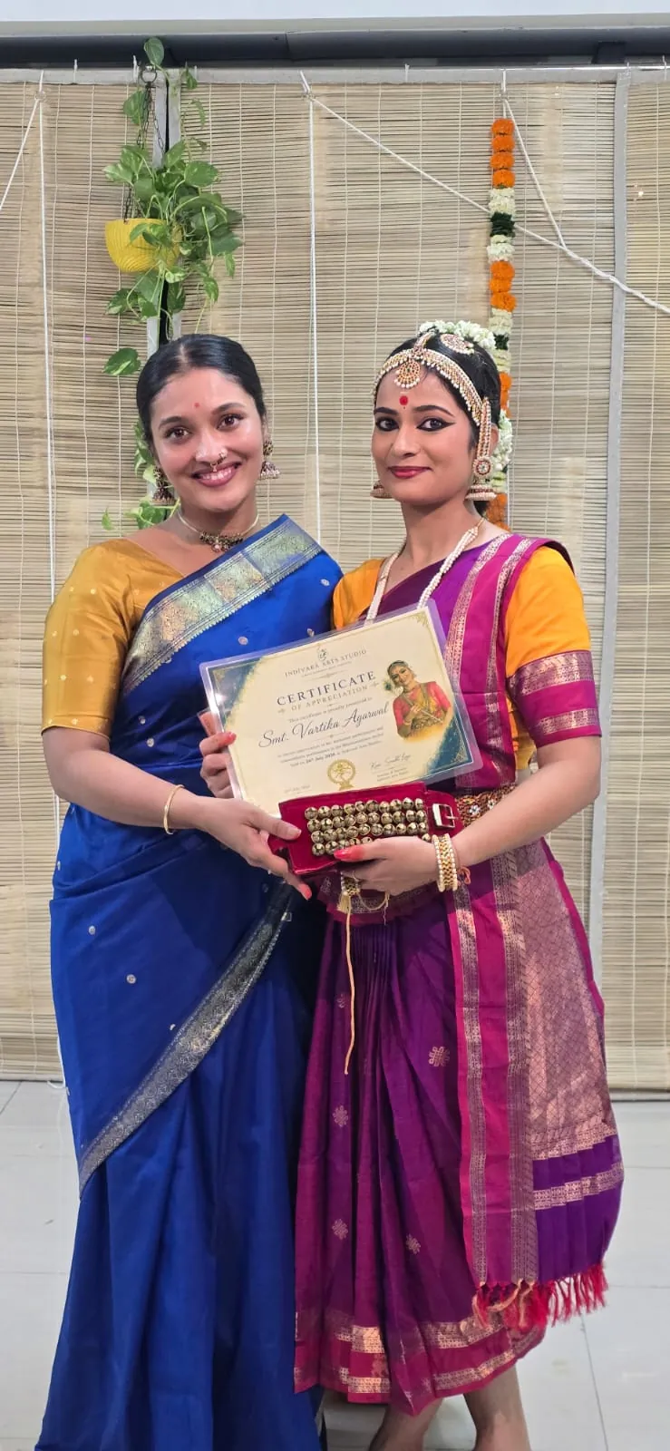A student receiving her certificate with her teacher
