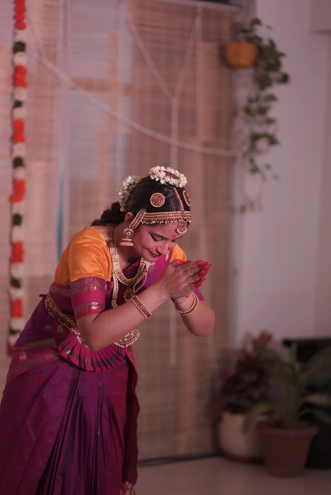 A dancer in costume offering pranam at her recital